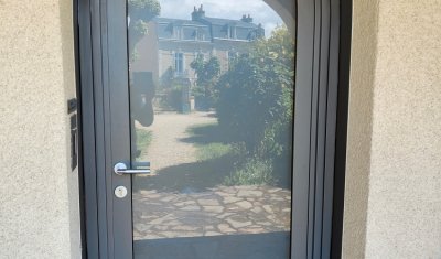 Pose rénovation porte cintrée mixte bois aluminium à Poitiers. Porte mixte bois chêne intérieur, aluminium gris 2900 extérieur, vitrage sablé, fermeture 3 points.